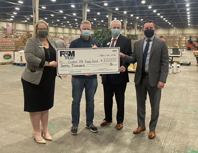 Bank and food bank representatives holding large vanity check