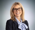 Image of Cindy Marconi wearing a navy blazer and a light blue scarf.