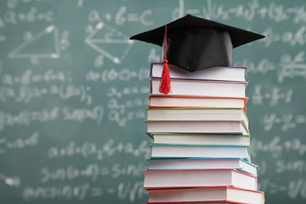 Stack of books with chalk board in the background
