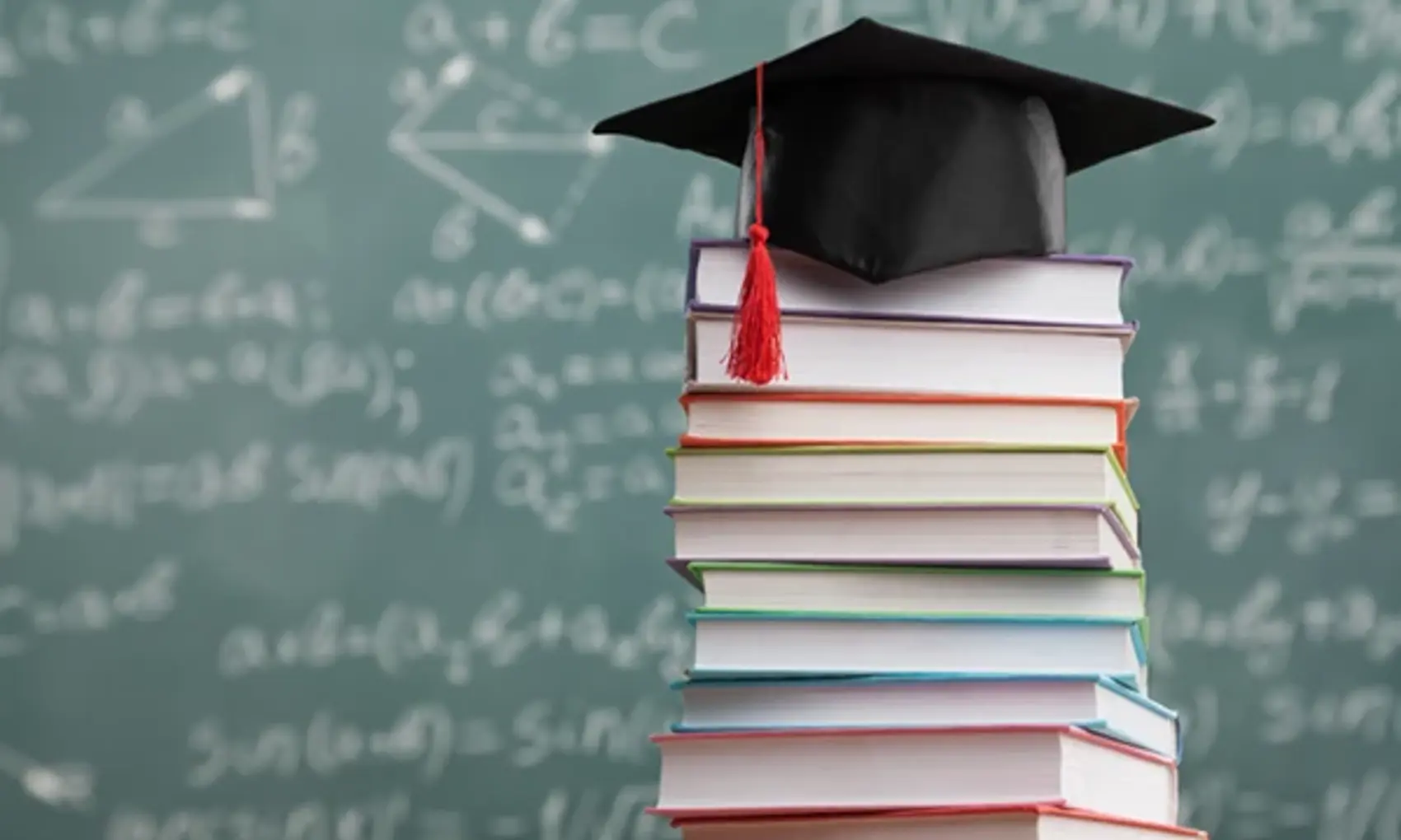 Stack of books with chalk board in the background
